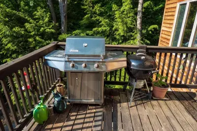 a grill and a bbq on a deck at Whimsical Lakefront Chalet in Monticello