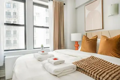 a bedroom with a white bed with towels on it at 73-1104 New Studio UWS Doorman Gym in New York