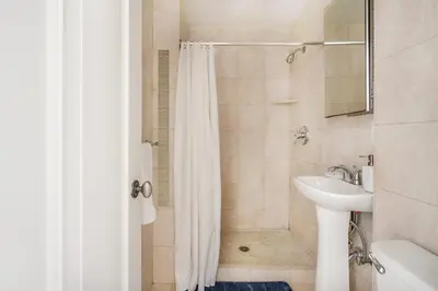 a bathroom with a shower curtain and a sink at 73-1104 New Studio UWS Doorman Gym in New York