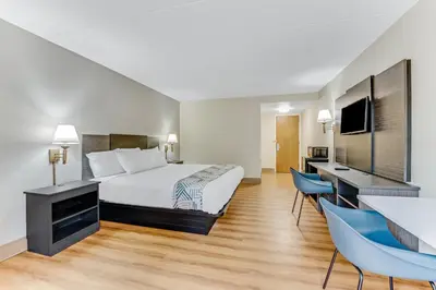 a hotel room with a bed and a desk and chairs at Red Carpet Inn & Suites in Philadelphia