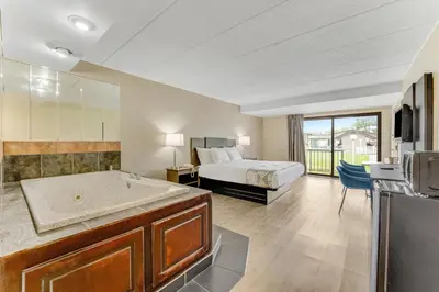 a bedroom with a bed and a tub in a room at Red Carpet Inn & Suites in Philadelphia