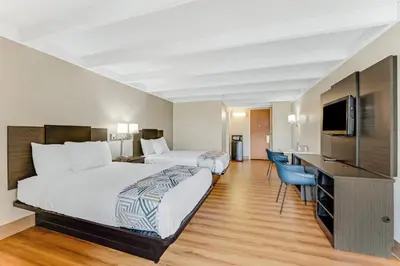 a hotel room with two beds and a flat screen tv at Red Carpet Inn & Suites in Philadelphia