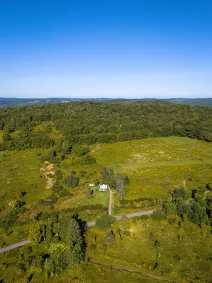 an aerial view of a field with a house in it at Chambers Hollow in Walton