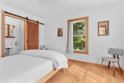 a bedroom with a bed and a window and a chair at Chambers Hollow in Walton