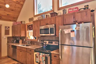 a kitchen with a stainless steel refrigerator and wooden cabinets at Whispering Pines Retreat in Albrightsville