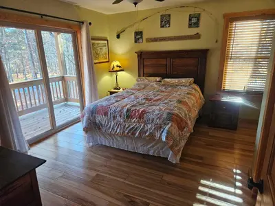 a bedroom with a bed in a room with windows at Whispering Pines Retreat in Albrightsville