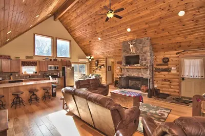 a living room with leather furniture and a fireplace at Whispering Pines Retreat in Albrightsville