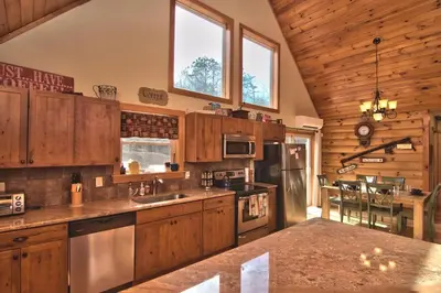a large kitchen with wooden cabinets and a counter top at Whispering Pines Retreat in Albrightsville
