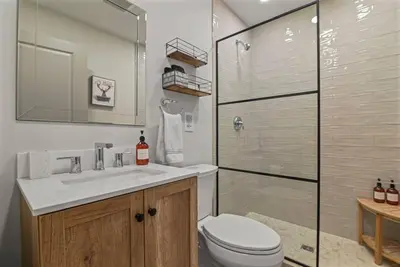 a bathroom with a toilet and a sink and a shower at 3BR, Lakeview, Hot Tub, Nintendo Switch - Deer Haven Poconos Retreat in Tobyhanna