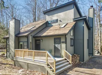 a small house with a porch and a deck at 3BR, Lakeview, Hot Tub, Nintendo Switch - Deer Haven Poconos Retreat in Tobyhanna