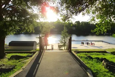 a walkway in a park with a lake in the background at 3BR, Lakeview, Hot Tub, Nintendo Switch - Deer Haven Poconos Retreat in Tobyhanna