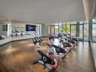 a gym with a row of treadmills and exercise bikes at AVE Florham Park - Furnished Apartment, Florham Park NJ in Florham Park