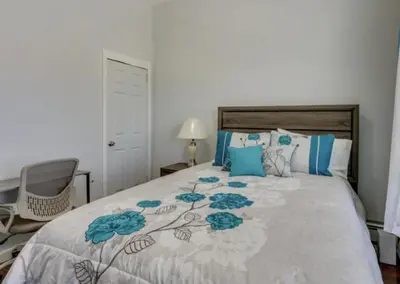 a bedroom with a bed with blue flowers on it at CLINTON HILLS - Newark in Newark