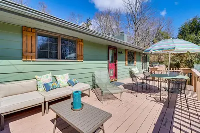 a patio with a couch and an umbrella and a table at Lovely Tobyhanna Getaway with Game Room and Fire Pit! in Tobyhanna