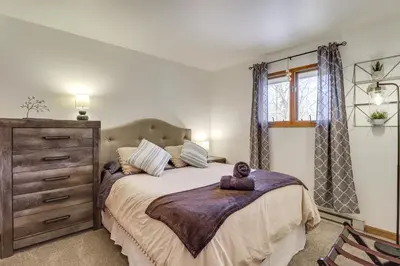 a bedroom with a large bed and a dresser at Lovely Tobyhanna Getaway with Game Room and Fire Pit! in Tobyhanna
