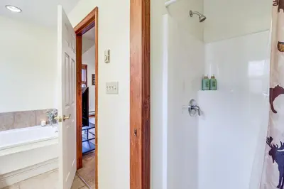 a bathroom with a bath tub and a sink at Serene Poconos Cabin with Hot Tub and Beach Access! in Albrightsville
