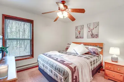 a bedroom with a bed and a ceiling fan at Serene Poconos Cabin with Hot Tub and Beach Access! in Albrightsville