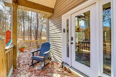 a blue chair sitting on the porch of a house at Serene Poconos Cabin with Hot Tub and Beach Access! in Albrightsville