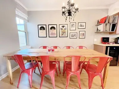 a dining room with a wooden table and red chairs at Larry's Lancaster Landing: with fully-fenced yard in Lancaster