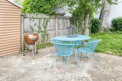 a table and two chairs and a grill in a yard at Larry's Lancaster Landing: with fully-fenced yard in Lancaster