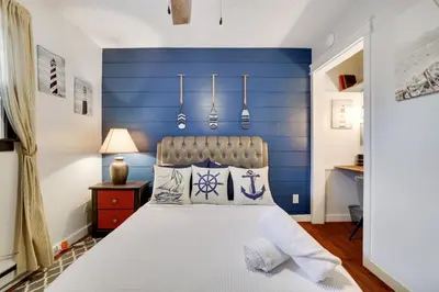 a bedroom with a blue accent wall and a bed at 2BR Cottage with Hot Tub in Tobyhanna