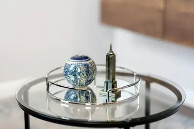 a glass table with a vase and a building on it at Big City Living: Elegant Apartment with NYC Vibes in Jersey City