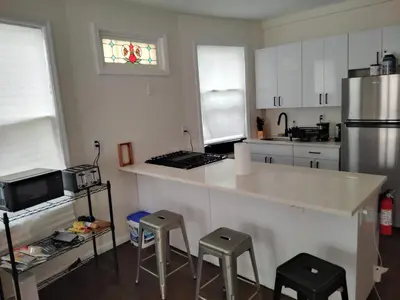 a kitchen with a counter with stools and a refrigerator at NYC HomeBnB in Jersey City
