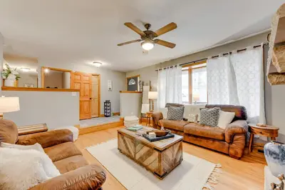 a living room with leather furniture and a ceiling fan at Pocono Lake House Hideaway Hot Tub and Theater Room in Pocono Lake