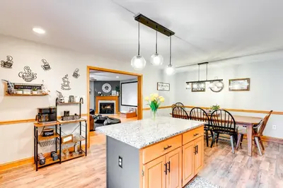 a kitchen and dining room with a table and a counter at Pocono Lake House Hideaway Hot Tub and Theater Room in Pocono Lake