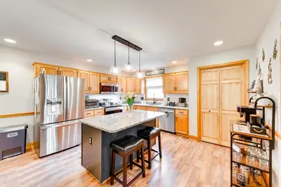 a kitchen with wooden cabinets and stainless steel appliances at Pocono Lake House Hideaway Hot Tub and Theater Room in Pocono Lake