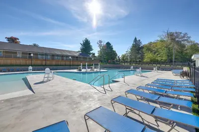 a group of blue chairs sitting around a swimming pool at Spacious Retreat 7 Mi to Tobyhanna State Park! in Tobyhanna