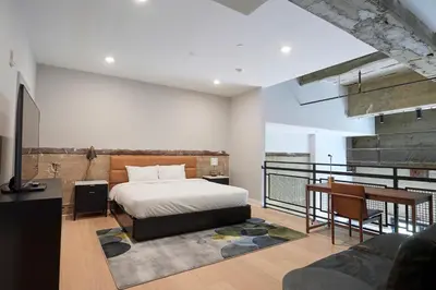 a bedroom with a bed and a table and a couch at Riversuites At The Battery in Philadelphia