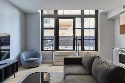a living room with a couch and a chair at Riversuites At The Battery in Philadelphia