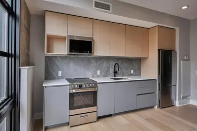 a kitchen with white cabinets and a stove at Riversuites At The Battery in Philadelphia