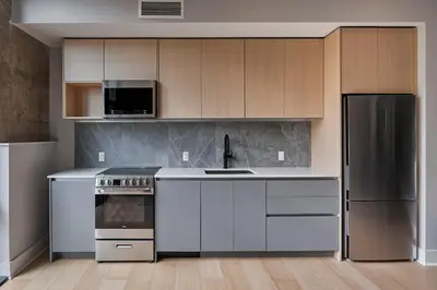 a kitchen with white appliances and wooden cabinets at Riversuites At The Battery in Philadelphia
