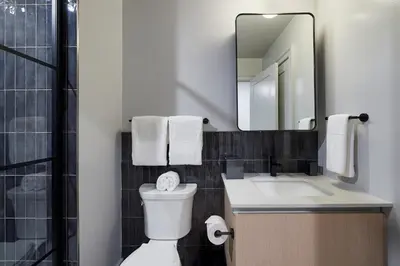a bathroom with a toilet and a sink and a mirror at Riversuites At The Battery in Philadelphia