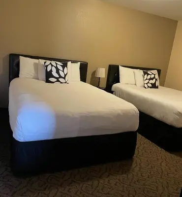 a hotel room with two beds with white sheets at Williamsport Grandview Hotel in Linden