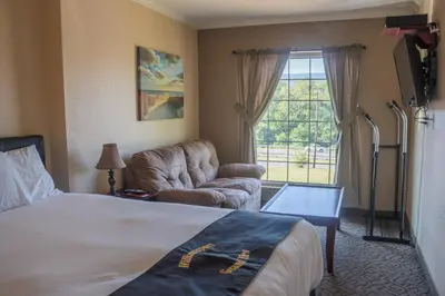 a hotel room with a bed and a chair and a window at Williamsport Grandview Hotel in Linden