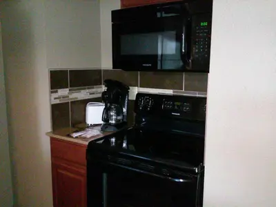 a kitchen with a black stove and a microwave at Williamsport Grandview Hotel in Linden