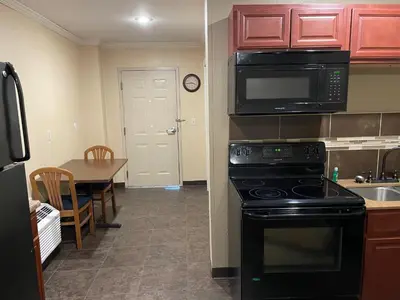 a kitchen with a black stove and a kitchen with a table at Williamsport Grandview Hotel in Linden