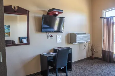 a room with a desk and a tv on the wall at Williamsport Grandview Hotel in Linden