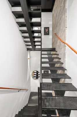 a staircase in a loft with a brick wall at Sosuite at The Loxley - Old City in Philadelphia