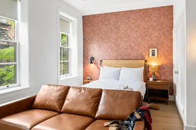 a living room with a couch in front of a bed at Sosuite at The Loxley - Old City in Philadelphia