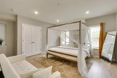 a bedroom with a canopy bed and a couch at Modern City Getaway Near Downtown Newark & NYC in Newark