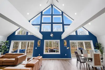 a living room with a blue wall and a table and chairs at Big Villa,4 Masters, Heated Pool, Hot Tub, Sauna in Blakeslee