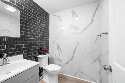 a bathroom with a white toilet and a sink at Big Villa,4 Masters, Heated Pool, Hot Tub, Sauna in Blakeslee