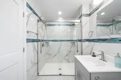 a white bathroom with a shower and a sink at Big Villa,4 Masters, Heated Pool, Hot Tub, Sauna in Blakeslee