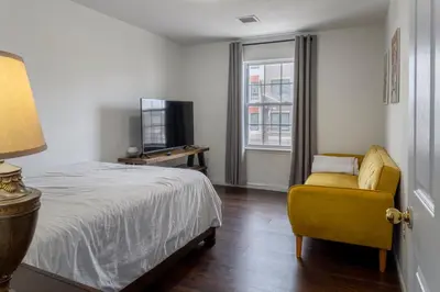 a bedroom with a bed and a chair and a television at Huge 3BR Urban Gem just 3 miles to NYC plus Free Parking in Jersey City