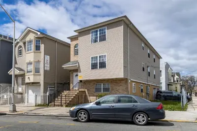 a blue car parked in front of a house at Huge 3BR Urban Gem just 3 miles to NYC plus Free Parking in Jersey City