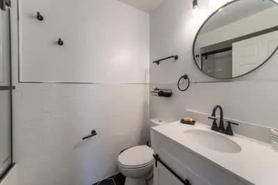 a white bathroom with a sink and a mirror at Huge 3BR Urban Gem just 3 miles to NYC plus Free Parking in Jersey City
